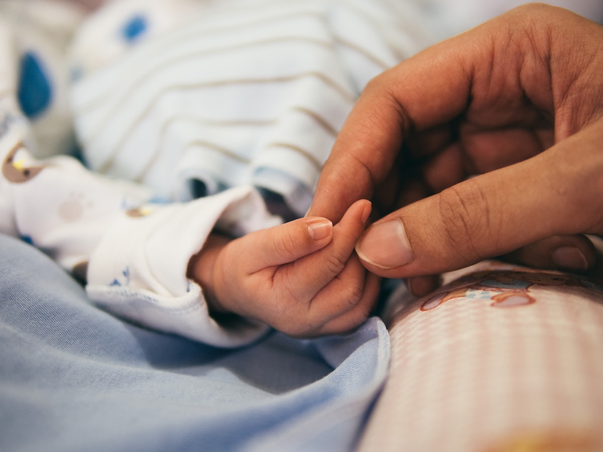 Newborn holding a parent's finger